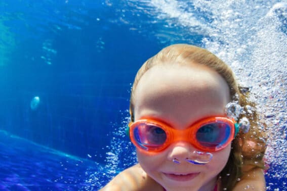 Im Pool tauchendes Kind mit Schwimmbrille