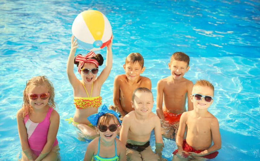 Little kids at swimming pool on sunny day